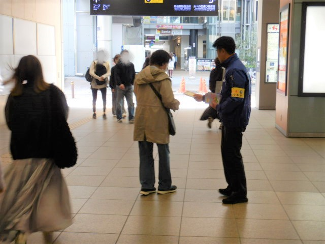 駅利用者に特殊詐欺被害防止を呼びかける区役所職員